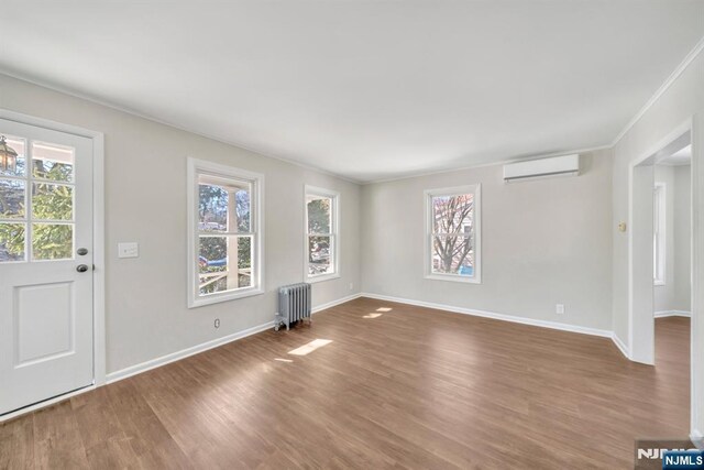 14 Harvard Ave, Wyckoff, NJ 07481 - entryway with radiator heating unit, a wall mounted air conditioner, plenty of natural light, wood finished floors, and ornamental molding