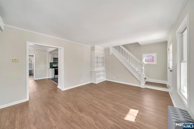 14 Harvard Ave, Wyckoff, NJ 07481 - unfurnished living room with radiator, wood finished floors, ornamental molding, stairway, and baseboards