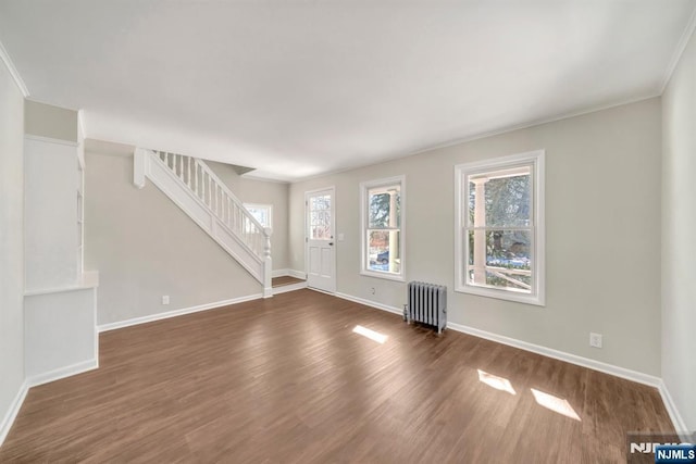 14 Harvard Ave, Wyckoff, NJ 07481 - unfurnished living room with radiator heating unit, plenty of natural light, dark wood-type flooring, baseboards, and ornamental molding