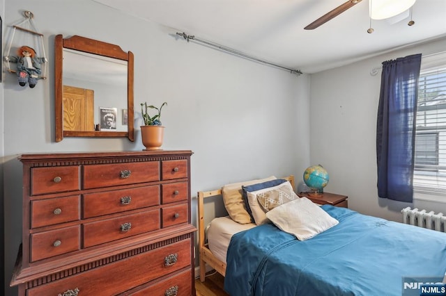 bedroom with radiator heating unit and ceiling fan