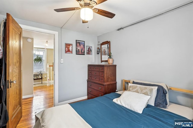 bedroom featuring light wood-type flooring, baseboards, and ceiling fan