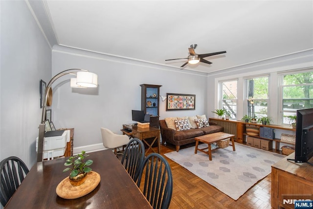 living room featuring ceiling fan, crown molding, and baseboards