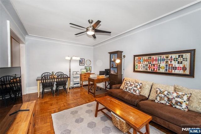 living area featuring a ceiling fan, crown molding, and baseboards