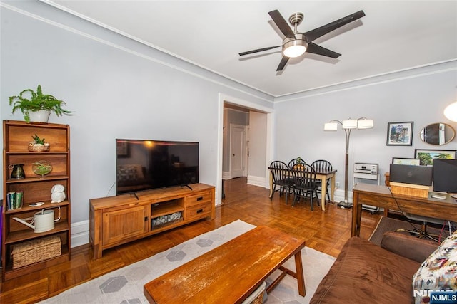 living room featuring ceiling fan, crown molding, and baseboards