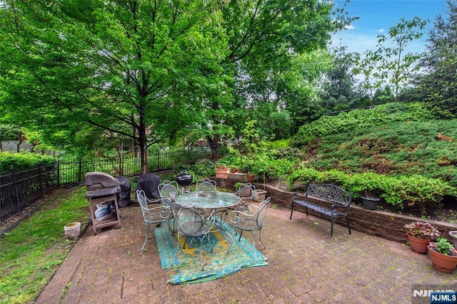 view of patio featuring fence, grilling area, and outdoor dining area