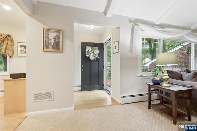 foyer entrance with a baseboard heating unit, wood finished floors, beam ceiling, and baseboards