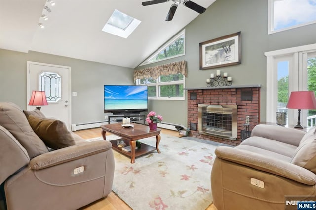 living area with a skylight, wood finished floors, ceiling fan, high vaulted ceiling, and a fireplace