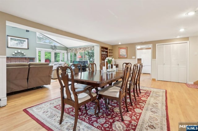 dining space with light wood finished floors, recessed lighting, and vaulted ceiling