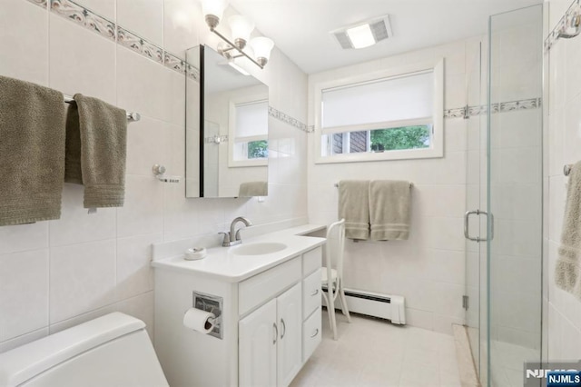 bathroom with tile walls, a baseboard radiator, a stall shower, vanity, and toilet