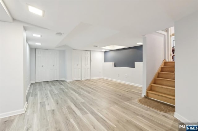 finished below grade area featuring wood finished floors, stairs, and baseboards
