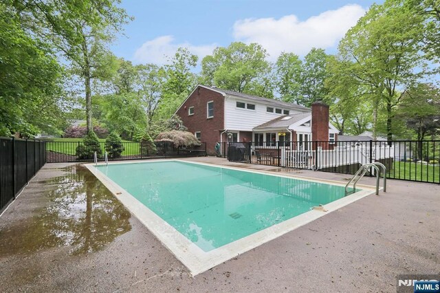 view of swimming pool featuring fence and a patio area