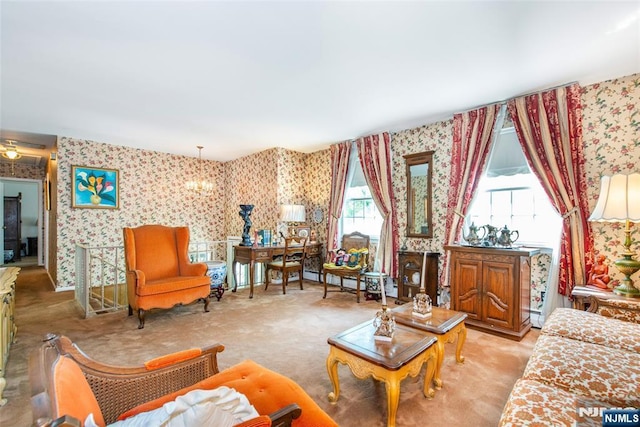 living room featuring wallpapered walls, light colored carpet, a baseboard radiator, and a chandelier