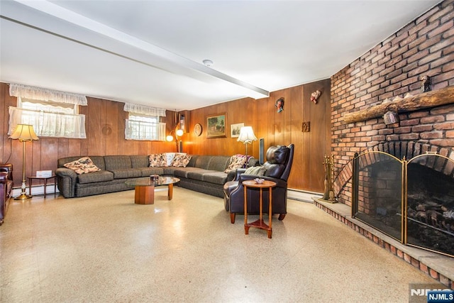 living room featuring wood walls, baseboard heating, a fireplace, and speckle patterned floor