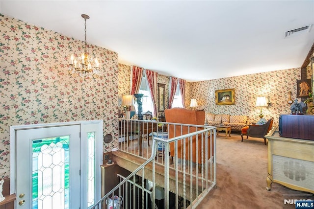 hallway featuring wallpapered walls, an upstairs landing, a chandelier, carpet flooring, and healthy amount of natural light