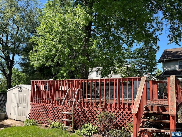 wooden deck featuring a storage shed and an outbuilding