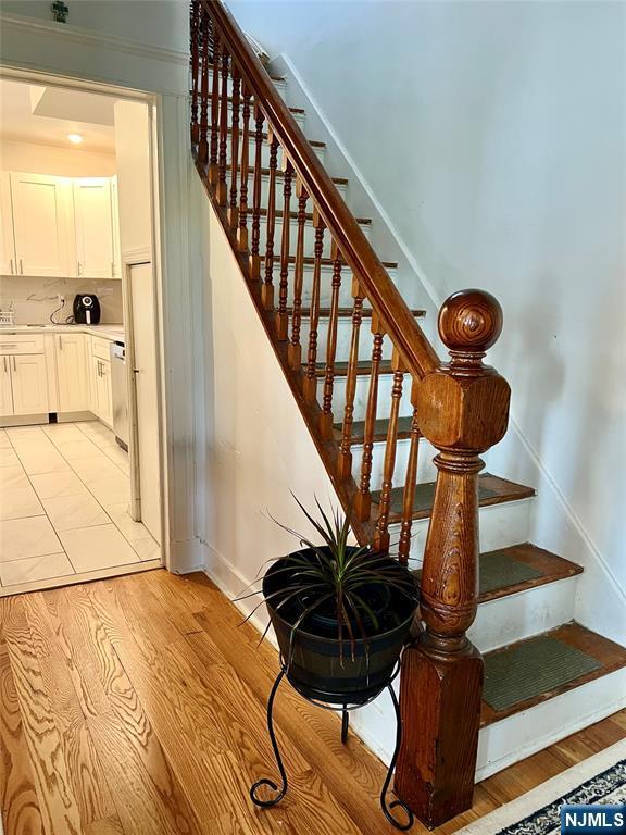 stairway with wood finished floors and baseboards