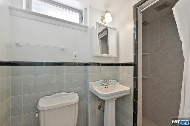 205 Elizabeth, Oradell, NJ 07649 - full bathroom with a tile shower, tile walls, toilet, and wainscoting