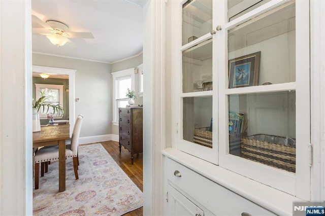 interior space featuring crown molding, wood finished floors, and baseboards