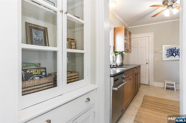 kitchen featuring a sink, light tile patterned floors, glass insert cabinets, crown molding, and ceiling fan