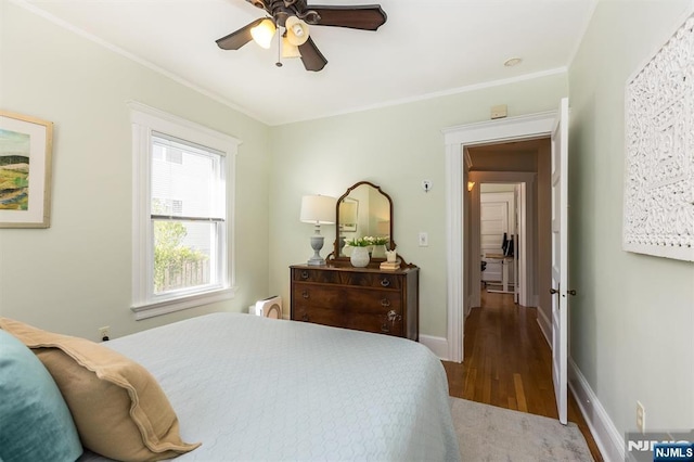 bedroom with wood finished floors, crown molding, baseboards, and a ceiling fan