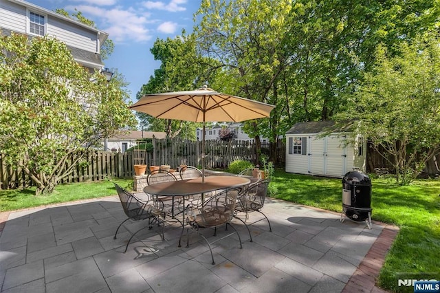 view of patio featuring outdoor dining space, a shed, and an outdoor structure