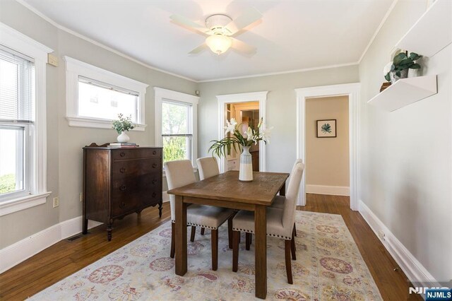 dining area with wood finished floors, a ceiling fan, crown molding, and baseboards
