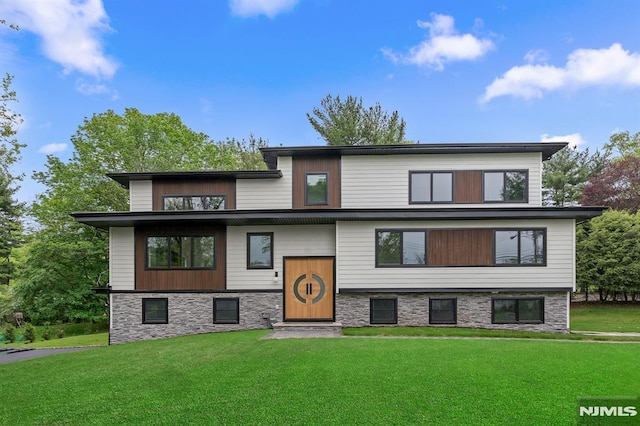view of front facade with a front yard and stone siding