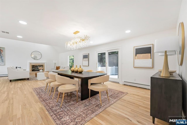 dining area with a baseboard heating unit, light wood finished floors, a chandelier, and recessed lighting