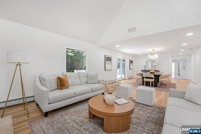 living area with light wood-type flooring, a baseboard radiator, recessed lighting, vaulted ceiling, and a baseboard heating unit