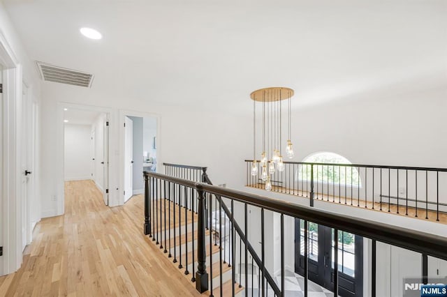 hallway featuring an upstairs landing, light wood-type flooring, recessed lighting, a chandelier, and baseboards