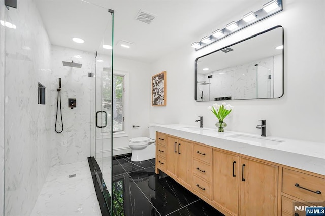 full bathroom featuring marble tiled floors, toilet, a marble finish shower, double vanity, and recessed lighting