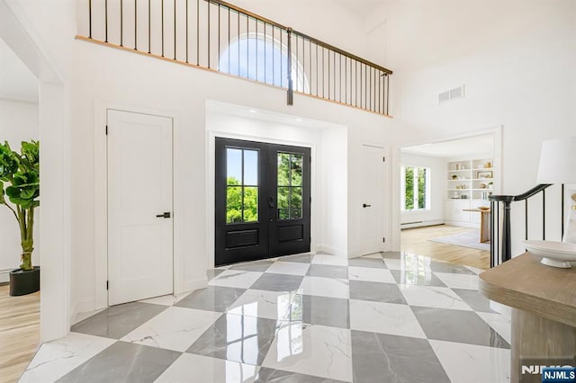 foyer entrance with a towering ceiling and baseboards