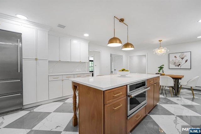 kitchen with stainless steel appliances, light countertops, white cabinetry, recessed lighting, and hanging light fixtures