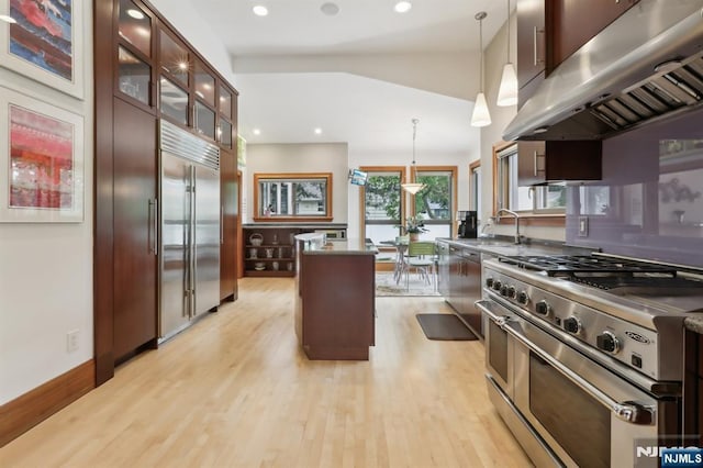 435 Cypress Ct, New Milford, NJ 07646 - kitchen with high end appliances, range hood, a kitchen island, light wood-style flooring, and a sink
