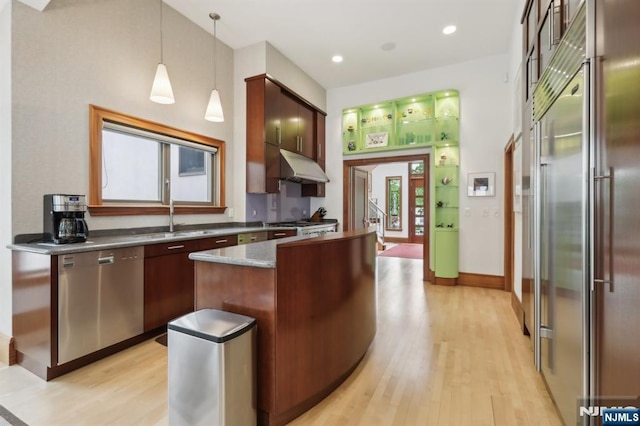 435 Cypress Ct, New Milford, NJ 07646 - kitchen with appliances with stainless steel finishes, a sink, light wood finished floors, under cabinet range hood, and dark countertops