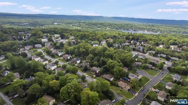 view of property location featuring a forest and nearby suburban area