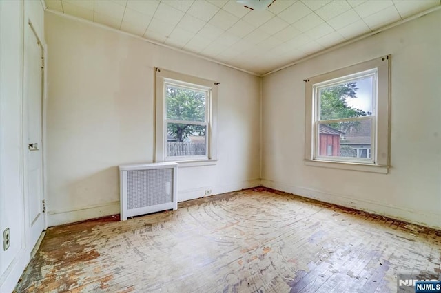 spare room with radiator heating unit, ornamental molding, and baseboards
