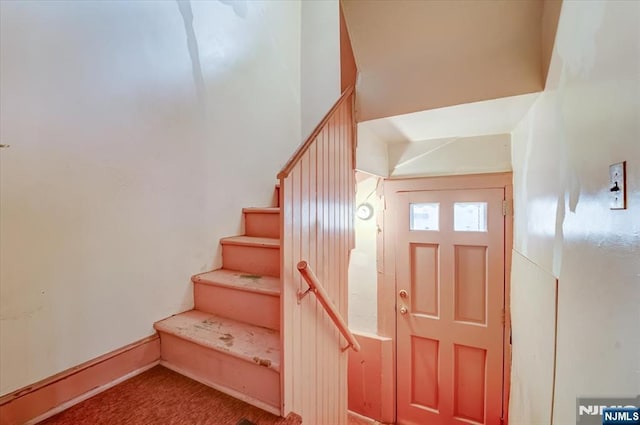 staircase featuring carpet flooring