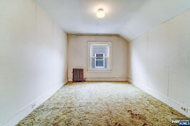 bonus room with radiator, lofted ceiling, and carpet floors