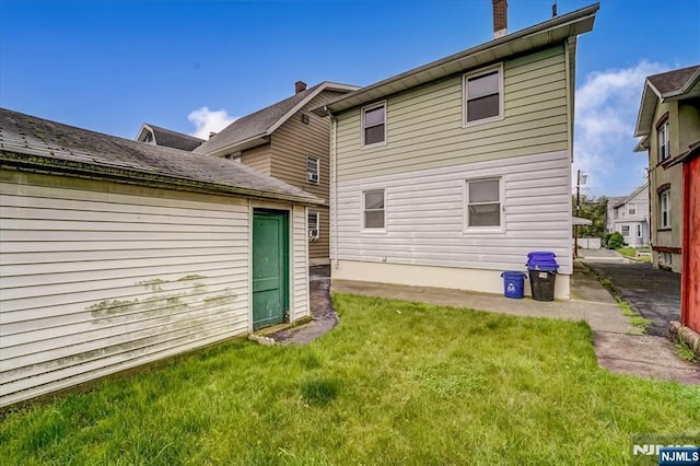 rear view of property featuring a yard and a chimney