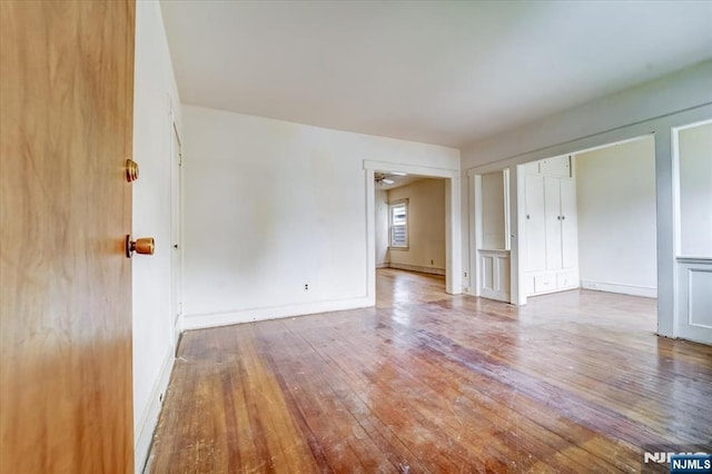 spare room featuring hardwood / wood-style floors and baseboards