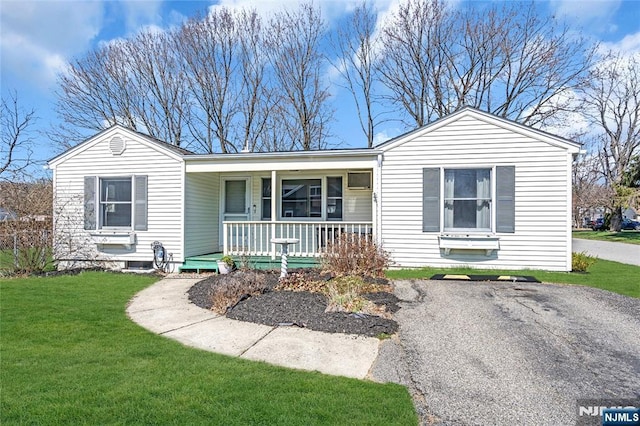 single story home featuring covered porch and a front yard
