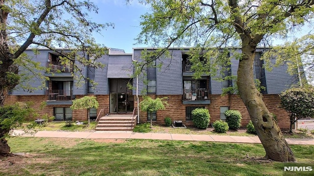 700 Schuyler Unit D16, Kearny, NJ 07032 - view of front facade with brick siding and a front lawn