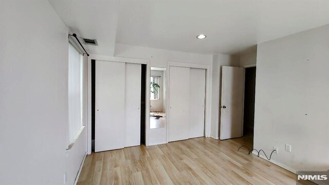 700 Schuyler Unit D16, Kearny, NJ 07032 - unfurnished bedroom featuring multiple closets, light wood finished floors, and recessed lighting