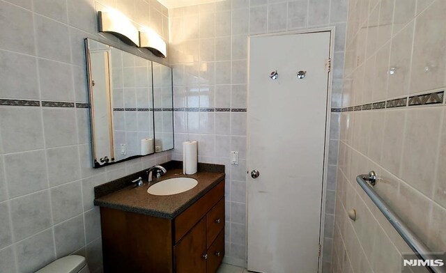 700 Schuyler Unit D16, Kearny, NJ 07032 - bathroom with tile walls, vanity, and backsplash