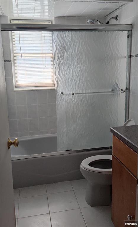700 Schuyler Unit D16, Kearny, NJ 07032 - bathroom with tile patterned floors, vanity, bath / shower combo with glass door, and toilet
