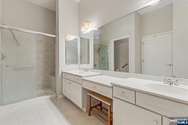 bathroom with a stall shower, tile patterned flooring, and double vanity