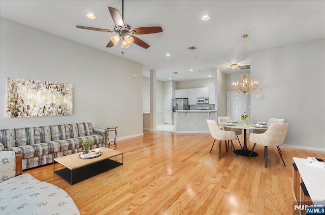 living area with ceiling fan, a chandelier, light wood-style floors, baseboards, and recessed lighting