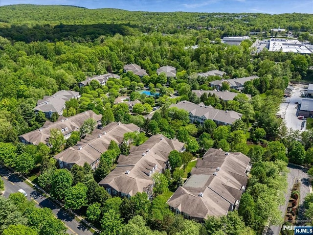 aerial view of residential area featuring a forest
