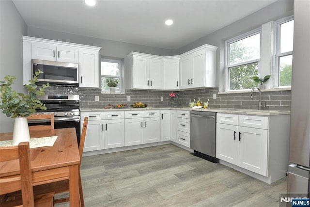 228 Ridgefield Ave, Bogota, NJ 07603 - kitchen with appliances with stainless steel finishes, light countertops, a sink, decorative backsplash, and recessed lighting